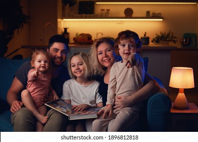 Happy Family Sitting Together At Cozy Home In The Evening