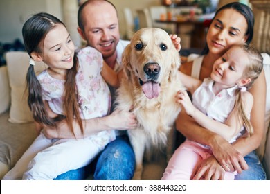 Happy Family Sitting Together With Their Dog