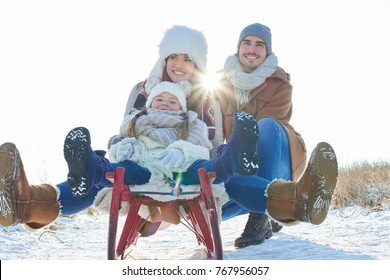 Happy Family With Sled In Winter Having Fun Together