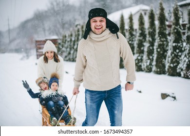 Happy Family Sledging Outside In Winter. Winter Time.