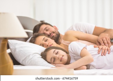 The happy family sleeping on the bed