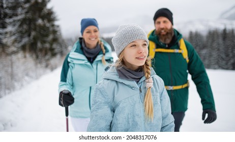 Happy Family With Small Daughter Walking Outdoors In Winter Nature, Tatra Mountains Slovakia.