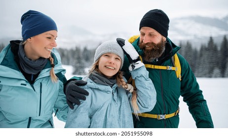 Happy Family With Small Daughter Walking Outdoors In Winter Nature, Tatra Mountains Slovakia.