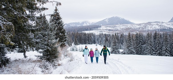 Happy Family With Small Daughters Walking Outdoors In Winter Nature, Tatra Mountains Slovakia.