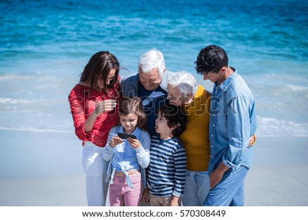 Happy family with a smartphone at the beach