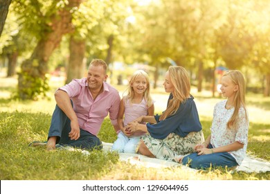 Fröhliche Familie mit Lächeln picknicken im Park an einem sonnigen Tag