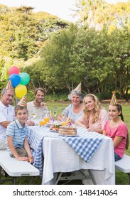 Happy Family Smiling At Camera At Birthday Party Outside At Picnic Table