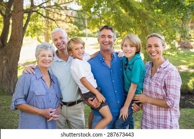 Happy Family Smiling At The Camera On A Sunny Day