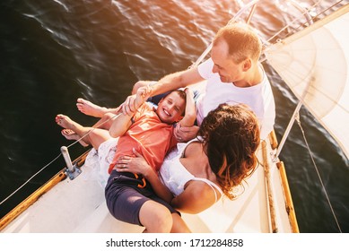 Happy Family With Son Resting On A Sailing Yacht