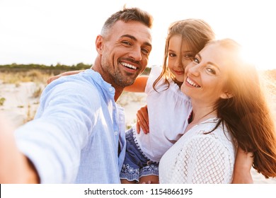 Happy family spending good time at the beach together, taking selfie - Shutterstock ID 1154866195