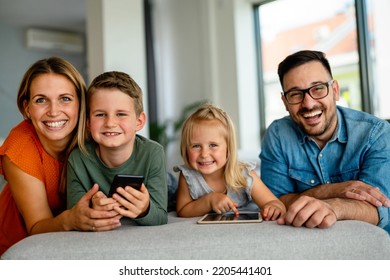 Happy family spending time at home with digital devices together. Technology people fun concept. - Shutterstock ID 2205441401