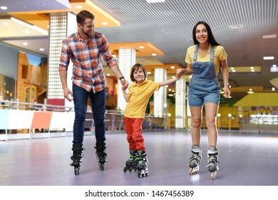 Happy Family Spending Time At Roller Skating Rink