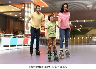 Happy Family Spending Time At Roller Skating Rink