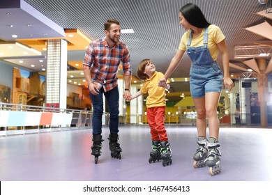 Happy Family Spending Time At Roller Skating Rink