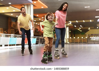 Happy Family Spending Time At Roller Skating Rink