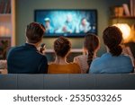 Happy family spending time together. Mother, father and children watching  TV, movies with popcorn in the evening at home.