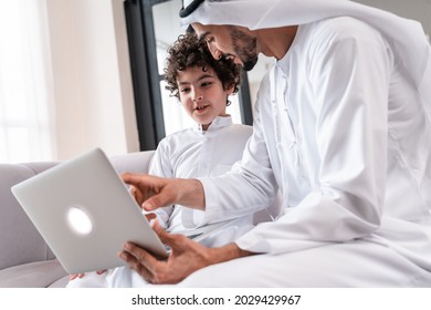 happy family spending time together. Arabian father and his son studying together on the computer