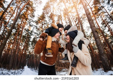 Happy Family Spending Time Together. Young Family With Children Walks In Winter Park.