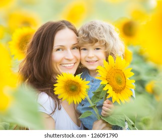 Happy Family In Spring Field Of Beautiful Sunflowers