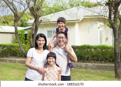 Happy family standing before their house