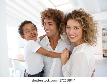 Happy Family Standing In Brand New Home