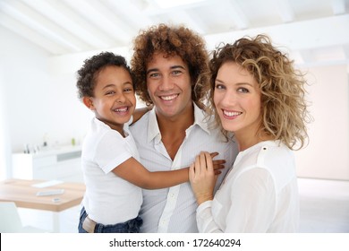 Happy Family Standing In Brand New Home