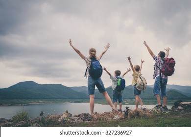 Happy family standing near the lake at the day time.  Concept of friendly family.