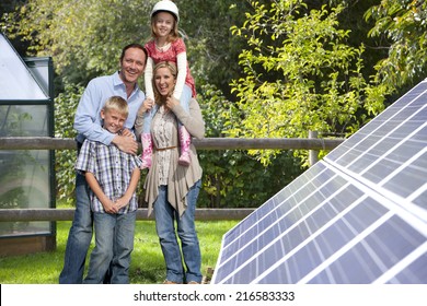 Happy family standing near large solar panels