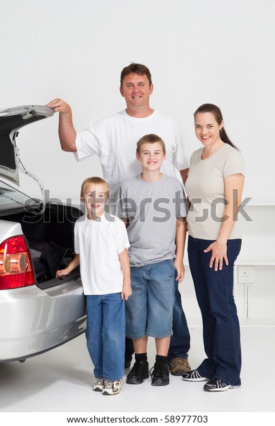 happy family standing next to family car and ready\
for a fun road trip