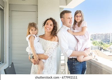 Happy Family Standing On Apartment, Hotel, Balcony 