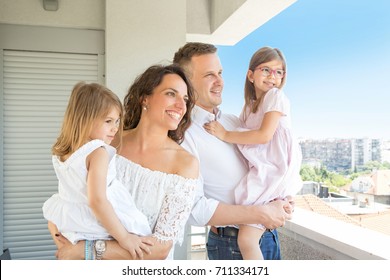 Happy Family Standing On Apartment, Hotel, Balcony 