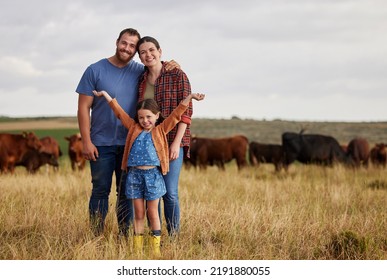 Happy family standing on a farm, cow in background and with a vision for growth in industry portrait. Countryside couple, people or farmer in a field of grass, cattle and free range livestock - Shutterstock ID 2191880055