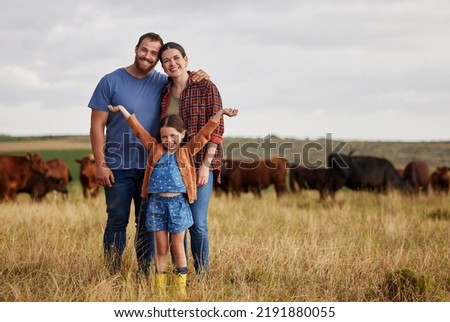 Happy family standing on a farm, cow in background and with a vision for growth in industry portrait. Countryside couple, people or farmer in a field of grass, cattle and free range livestock