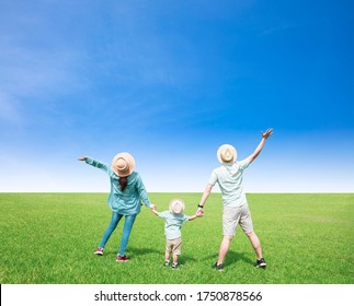 Happy  Family Standing On The Grass And Watching The Sky