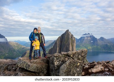 Happy family, standing on a rock and looking over Segla mountain on Senja island, North Norway. Amazing beautiful landscape and splendid nature in scandinavian country Norway