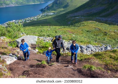 Happy family, standing on a rock and looking over Segla mountain on Senja island, North Norway. Amazing beautiful landscape and splendid nature in scandinavian country