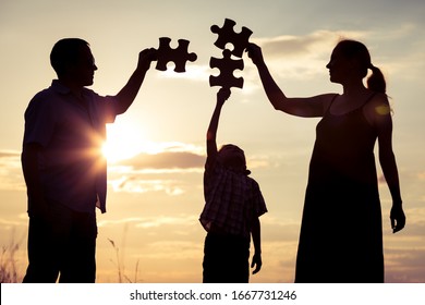 Happy family standing in the park at the sunset time. People having fun outdoors. Concept of friendly family. - Shutterstock ID 1667731246
