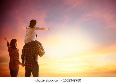 Happy Family Standing And Watching The Sunset