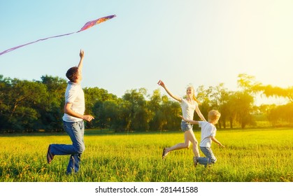 happy family in summer nature. Dad, mom and son child flying a kite - Powered by Shutterstock