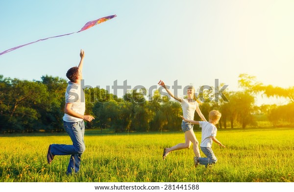 happy family in summer nature. Dad, mom and son child flying a kite