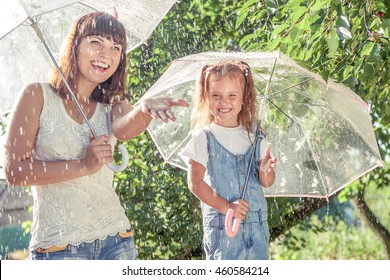 Happy Family  In The Summer Sunny Rain. Funny Mother And Daughter Playing Outdoors Hot Day With Umbrella. Joyful Emotions