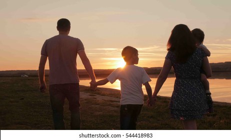 Happy Family At Sunset Silhouette Of The Water