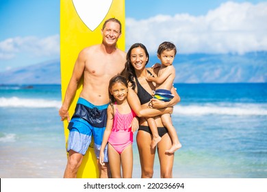 Happy Family With Surfboards On The Beach In Hawaii