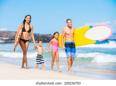 Happy Family With Surfboards On The Beach In Hawaii