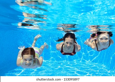 Happy Family Swim Underwater In Pool And Having Fun, Mother And Children On Vacation 