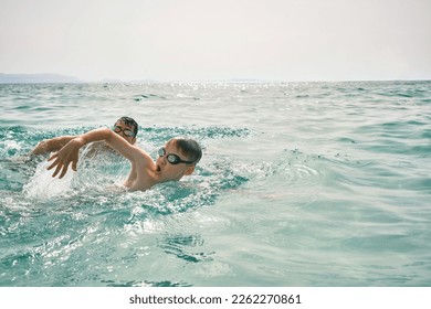 Happy family in swimming goggles, father and son bonding, swim in the sea looking at view enjoying summer vacation. Togetherness Friendly concept - Powered by Shutterstock