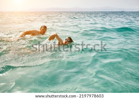 Happy family in swimming goggles, father and son bonding, swim in the sea looking at view enjoying summer vacation. Togetherness Friendly concept