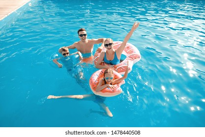 Happy Family Swimming In Pool On Summer Day