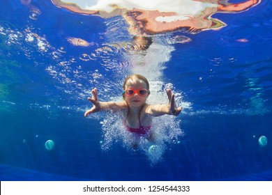 Happy Family In Swimming Pool. Smiling Child In Goggles Swim, Dive In Pool With Fun - Jump Deep Down Underwater. Healthy Lifestyle, People Water Sport Activity, Swimming Lessons On Holidays With Kids