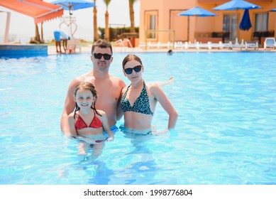 Happy Family In Swimming Pool At Water Park